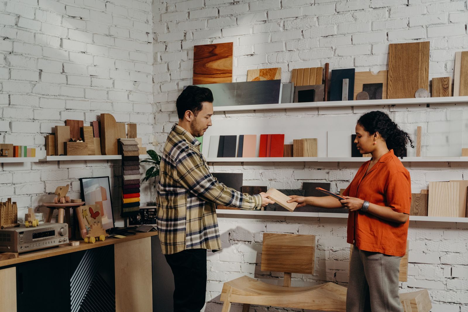 Klant en medewerker die samen materialen bekijken in een winkel